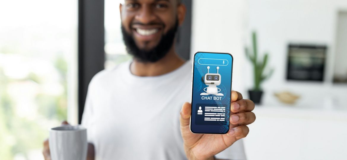 Cheerful black guy showing phone with chatbot screen