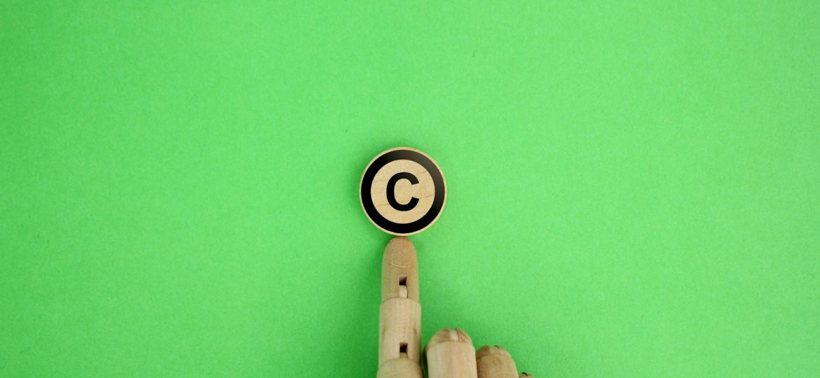wooden hand and letter C. copyright concept.